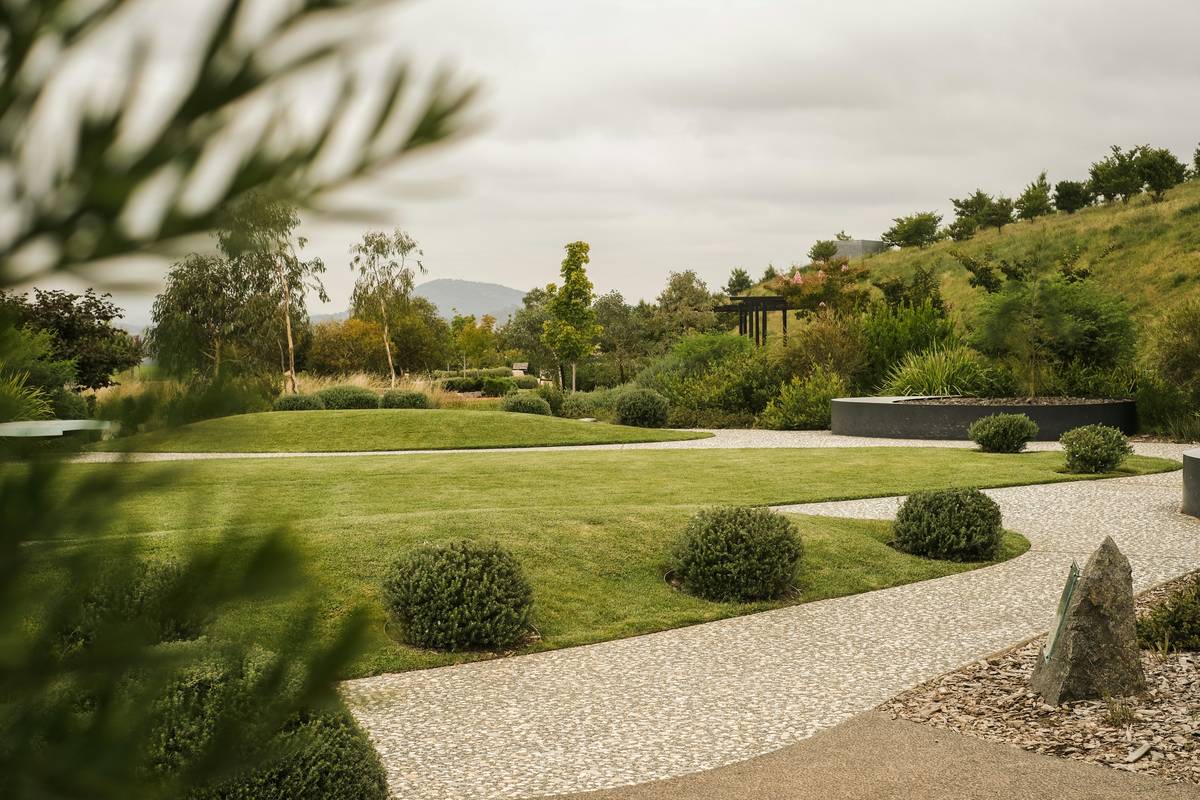 DIY landscaping garden bridge installation with proper footings and native landscaping